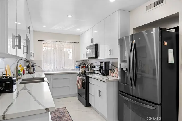 a kitchen with a refrigerator a sink a stove a microwave and cabinets