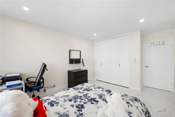 a bedroom with bed a table and chair