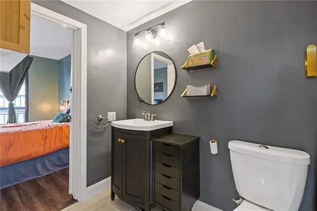 a bathroom with a toilet a sink and mirror