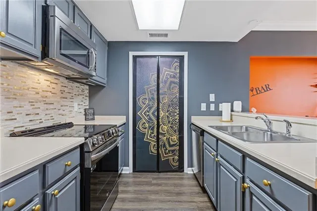 a kitchen with stainless steel appliances granite countertop a sink stove and refrigerator