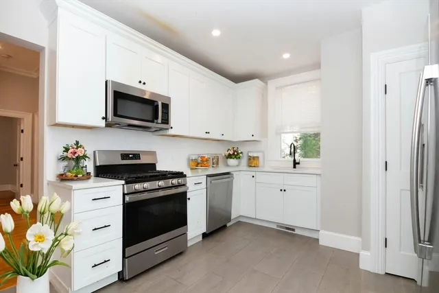 a kitchen with white cabinets and white appliances