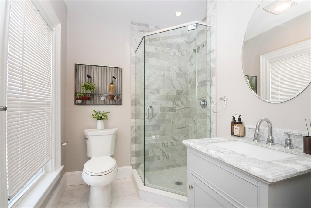 14 Grant Street Boston, MA 02125 - Photo 15 of 17 a bathroom with a granite countertop sink a toilet and shower