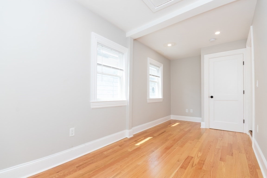 14 Grant Street Boston, MA 02125 - Photo 8 of 17 an empty room with wooden floor and windows
