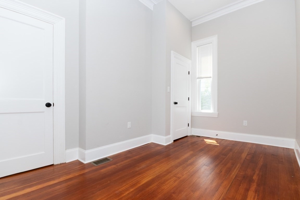 14 Grant Street Boston, MA 02125 - Photo 10 of 17 an empty room with wooden floor