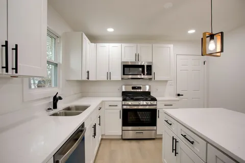 a kitchen with a sink stove and microwave