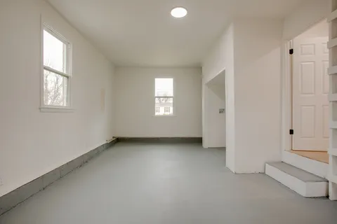 an empty room with windows and closet