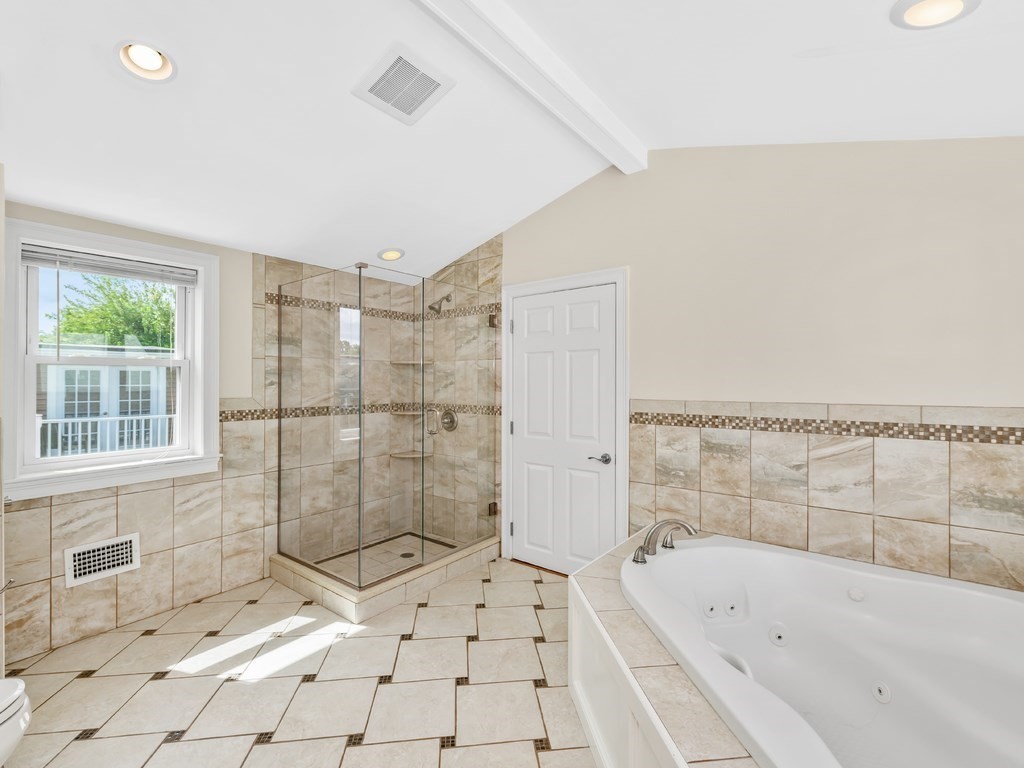 194 School Street, Unit 194 Watertown, MA 02472 - Photo 21 of 24 a bathroom with a bathtub and next to a window
