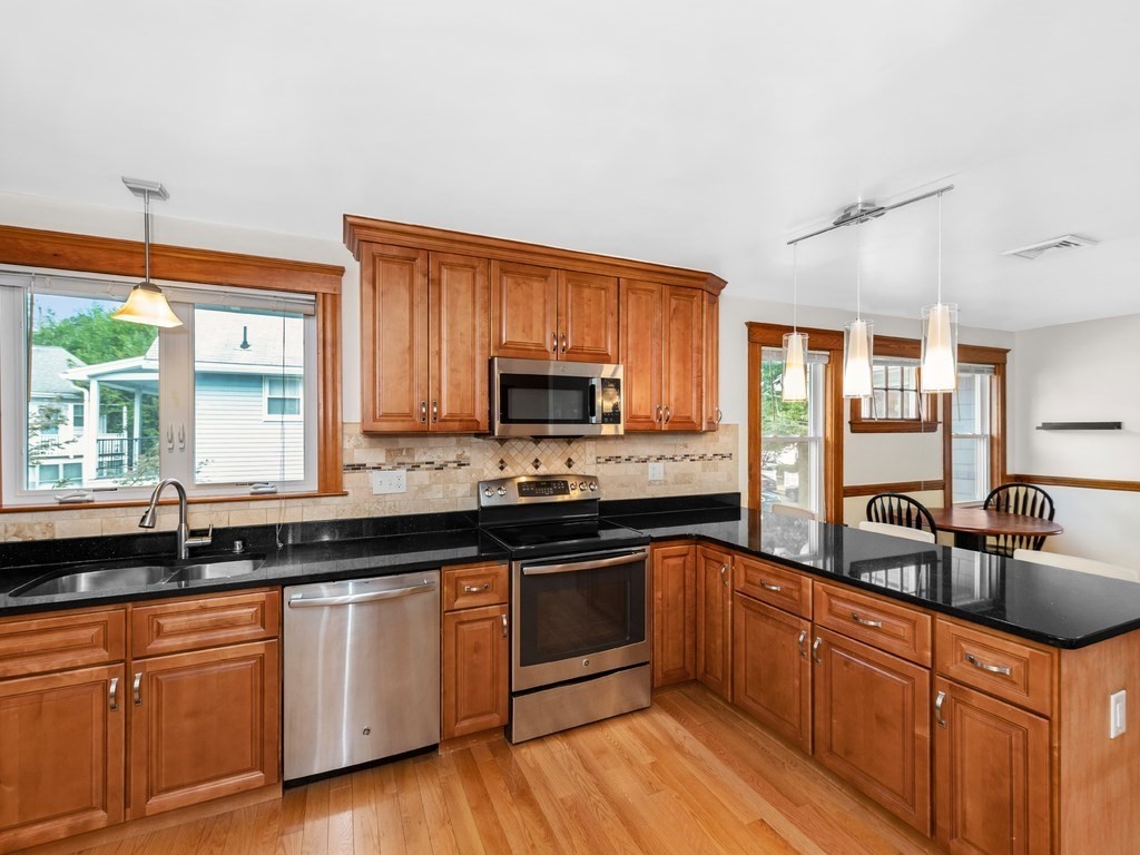 194 School Street, Unit 194 Watertown, MA 02472 - Photo 9 of 24 a kitchen with granite countertop a sink and cabinets