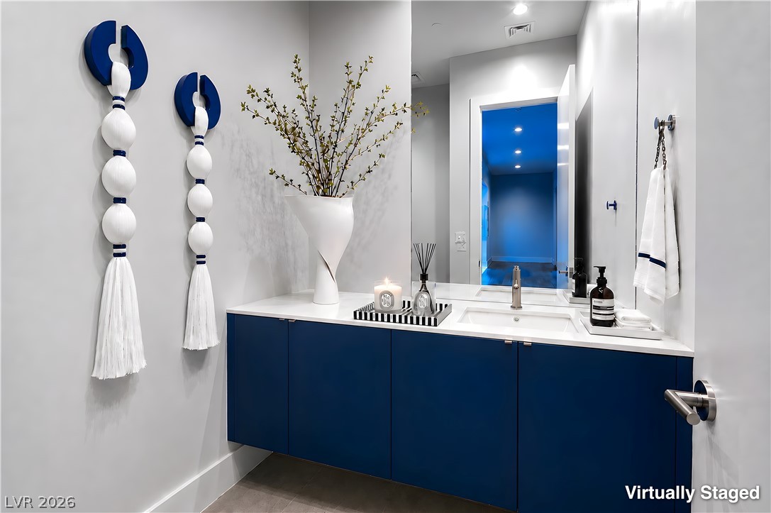25 Falling Ridge Lane Henderson, NV 89011 - Photo 12 of 48 A striking powder room features a floating vanity, ample storage, and a large mirror.