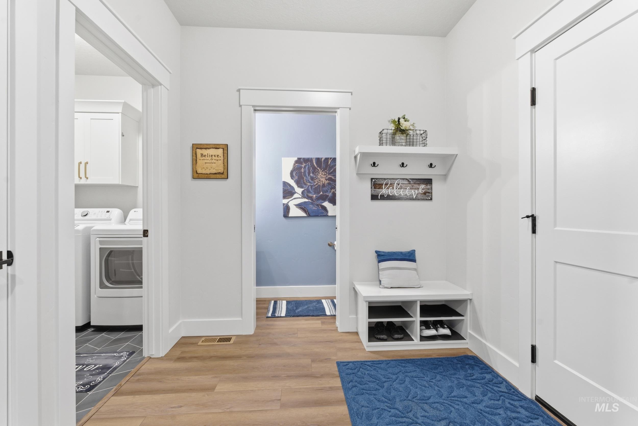 6347 South Utmost Lane Meridian, ID 83642 - Photo 27 of 37 Garage entryway featuring wood-finish flooring, white trim, and a built-in bench with shoe storage. Access to the laundry room, half bath and garage.