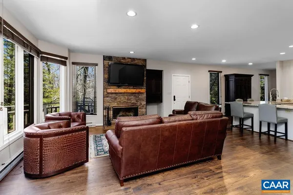 a living room with furniture a flat screen tv and a large window