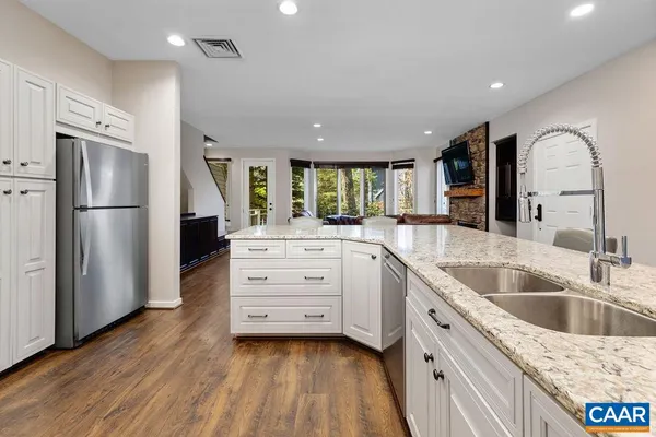 a kitchen with granite countertop a sink and a refrigerator