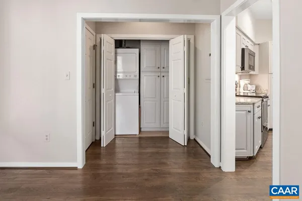 a view of a hallway with wooden floor and closet area