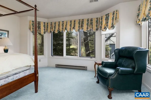 a bedroom with furniture and a large window
