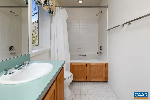 a bathroom with a tub sink mirror and shower