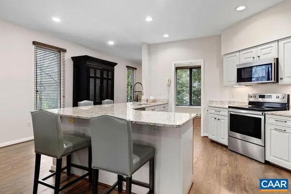 a kitchen with stainless steel appliances kitchen island granite countertop a stove a sink and a microwave
