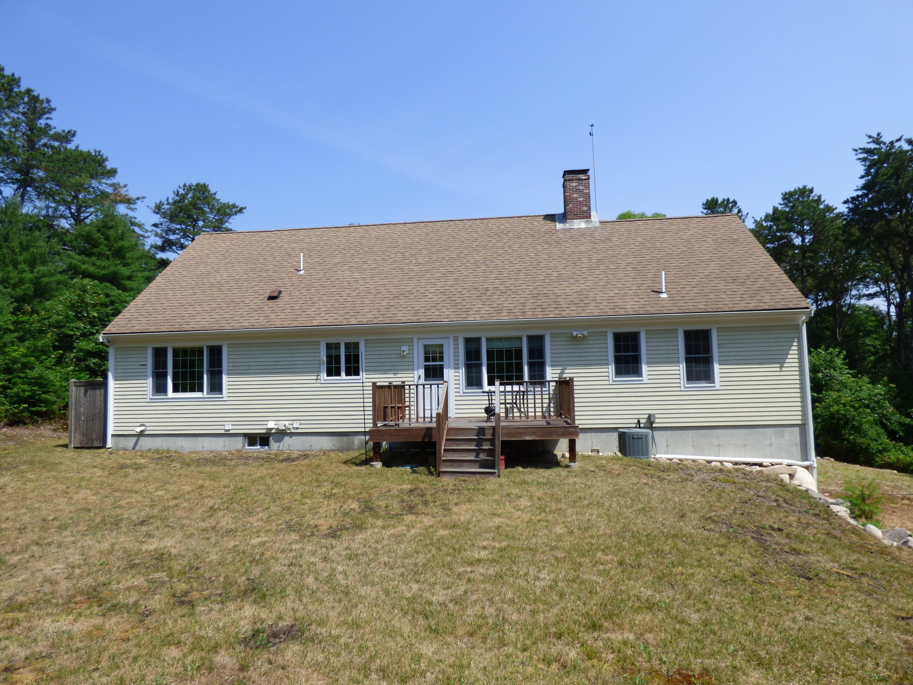 229 Woodside Road West Barnstable, MA 02668 - Photo 19 of 26 a front view of house with yard and trees in the background
