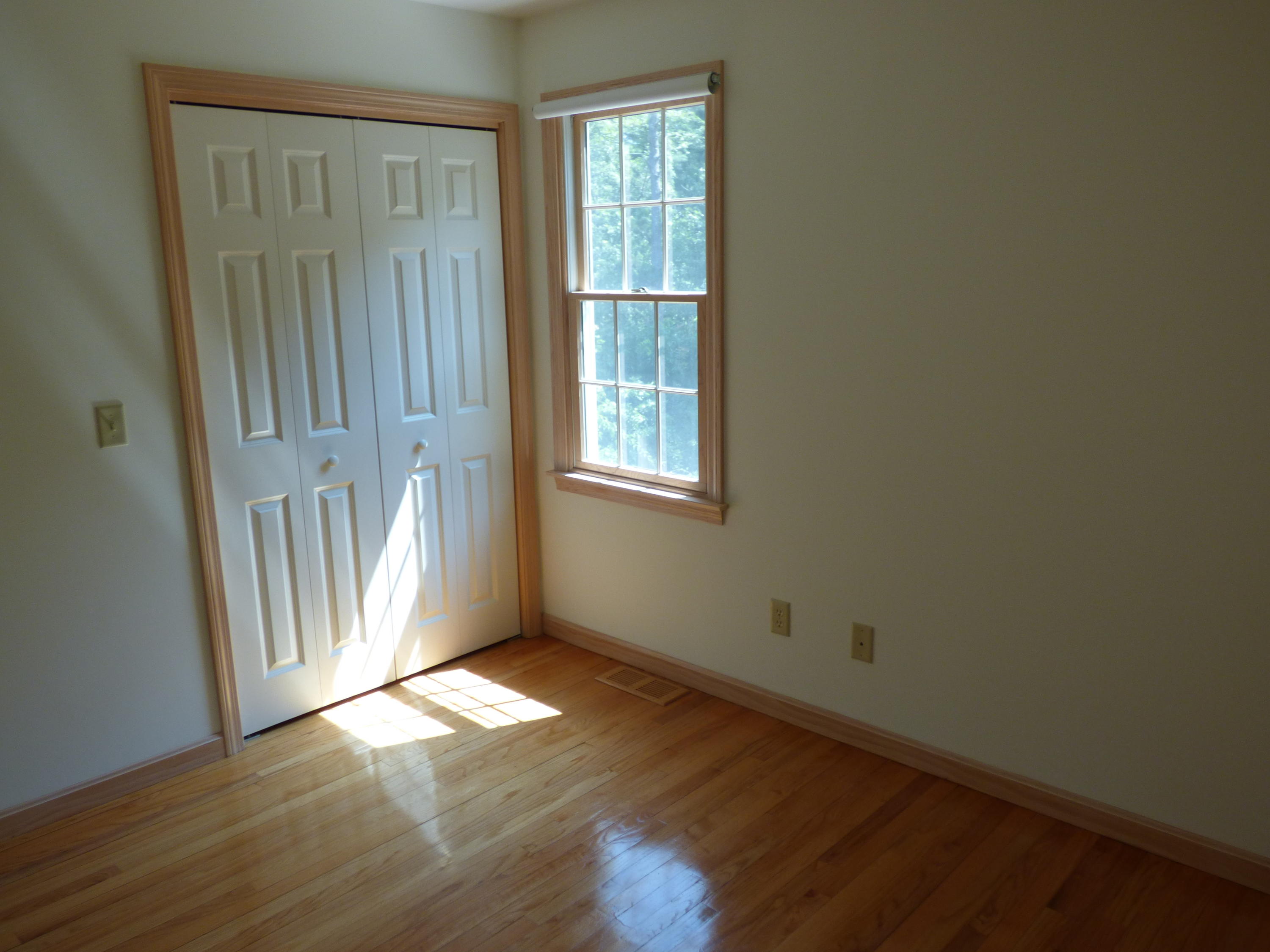 229 Woodside Road West Barnstable, MA 02668 - Photo 9 of 26 an empty room with wooden floor and windows