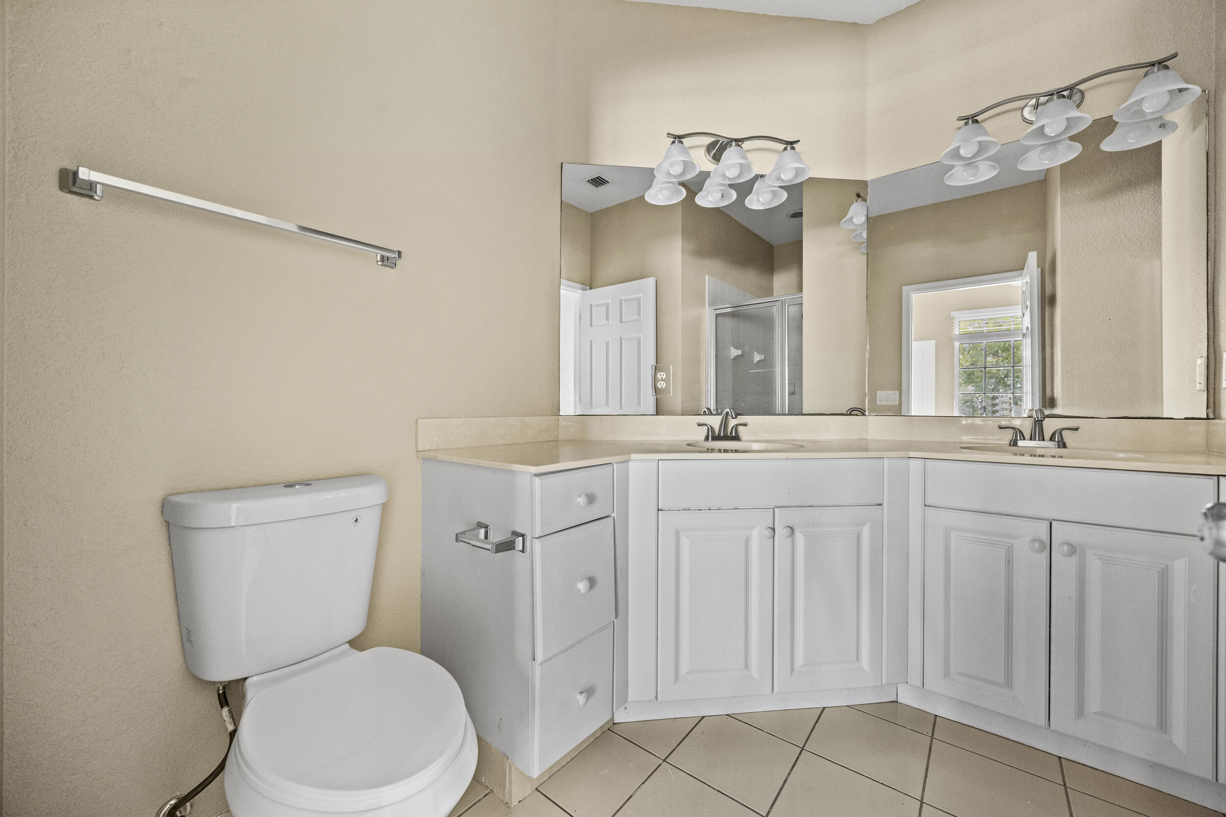 1982 Freeport Drive Riviera Beach, FL 33404 - Photo 14 of 31 a bathroom with a toilet a sink a mirror and vanity