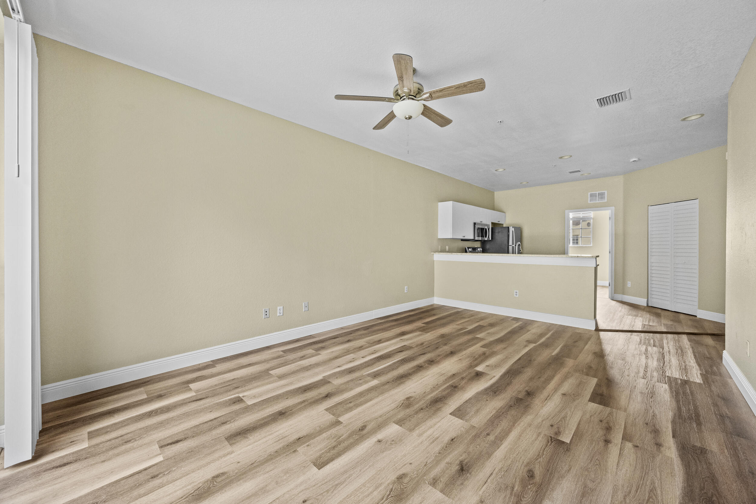 1982 Freeport Drive Riviera Beach, FL 33404 - Photo 20 of 31 a view of empty room with wooden floor and ceiling fan