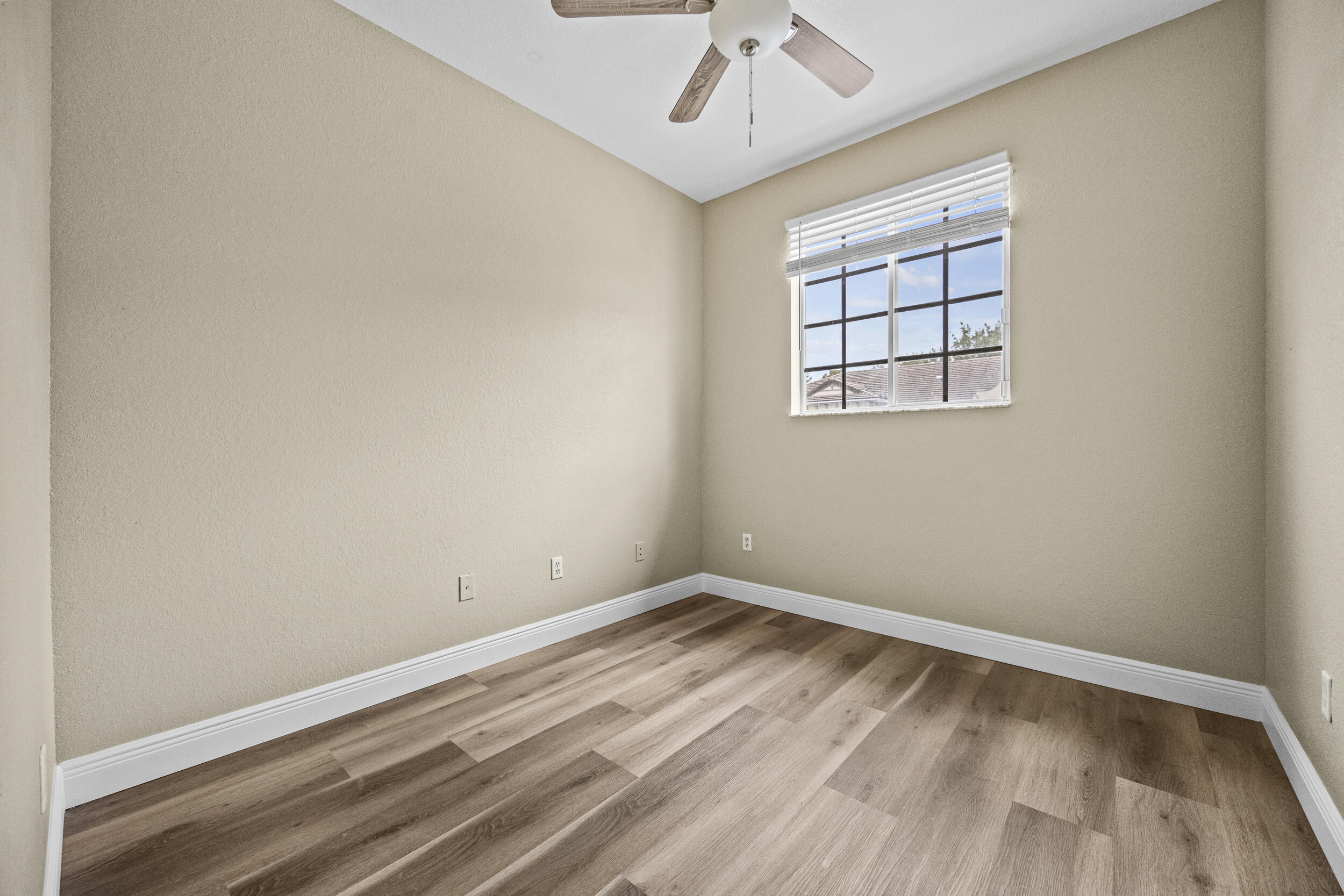 1982 Freeport Drive Riviera Beach, FL 33404 - Photo 6 of 31 wooden floor in an empty room with a window