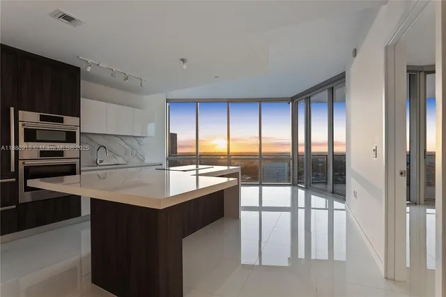 a kitchen with kitchen island a sink appliances and cabinets