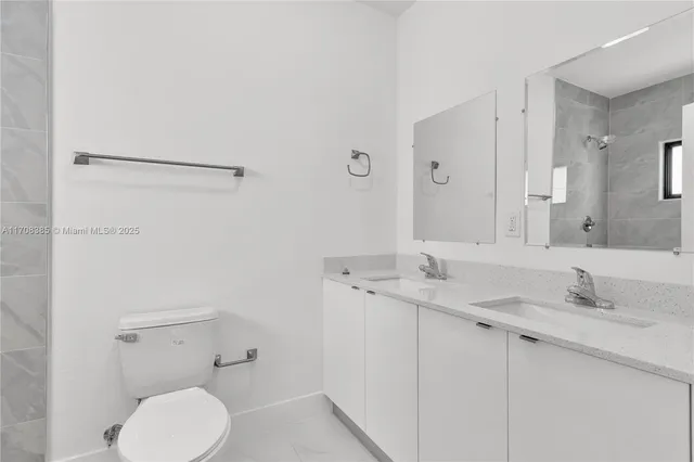 a bathroom with a granite countertop sink mirror and toilet