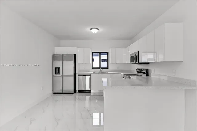 a large white kitchen with cabinets
