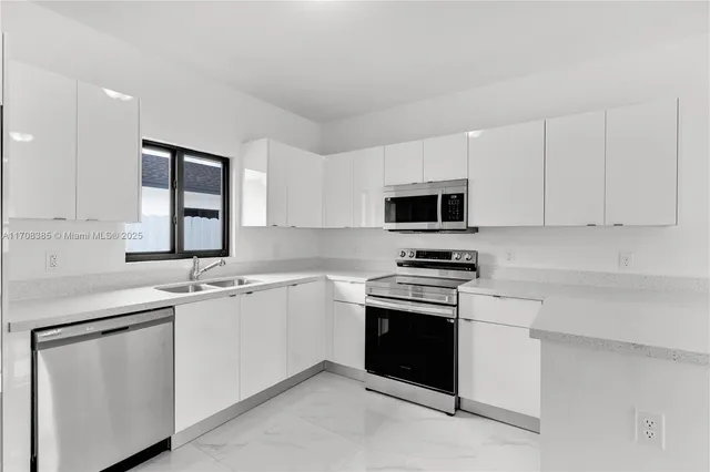 a kitchen with sink a microwave and cabinets