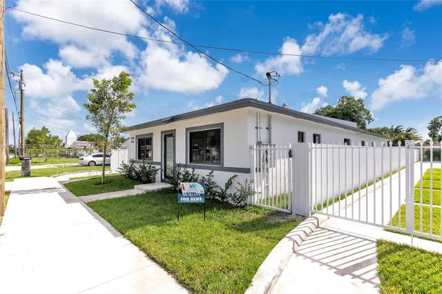 a view of a house with backyard and sitting area