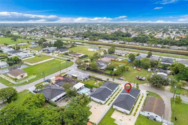 an aerial view of a city with lots of residential buildings ocean and mountain view in back