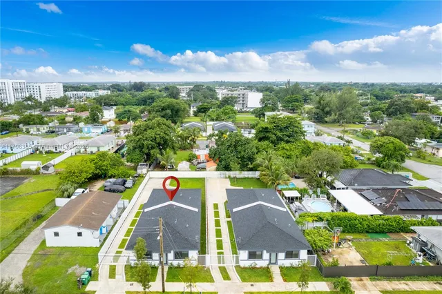 an aerial view of residential houses with outdoor space and swimming pool