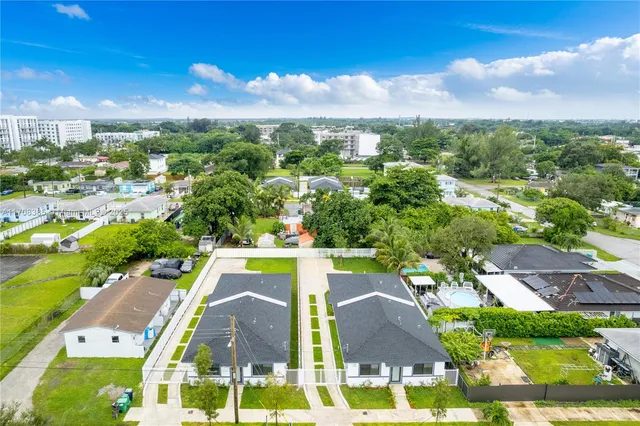 an aerial view of residential houses with outdoor space and swimming pool
