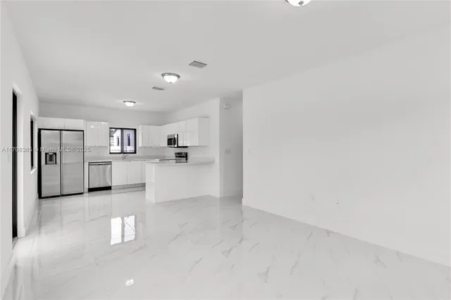 a view of a kitchen with refrigerator and windows