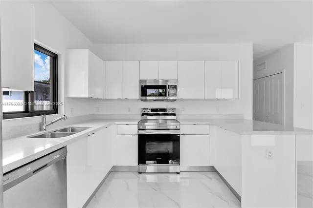 a kitchen with a sink cabinets and stainless steel appliances