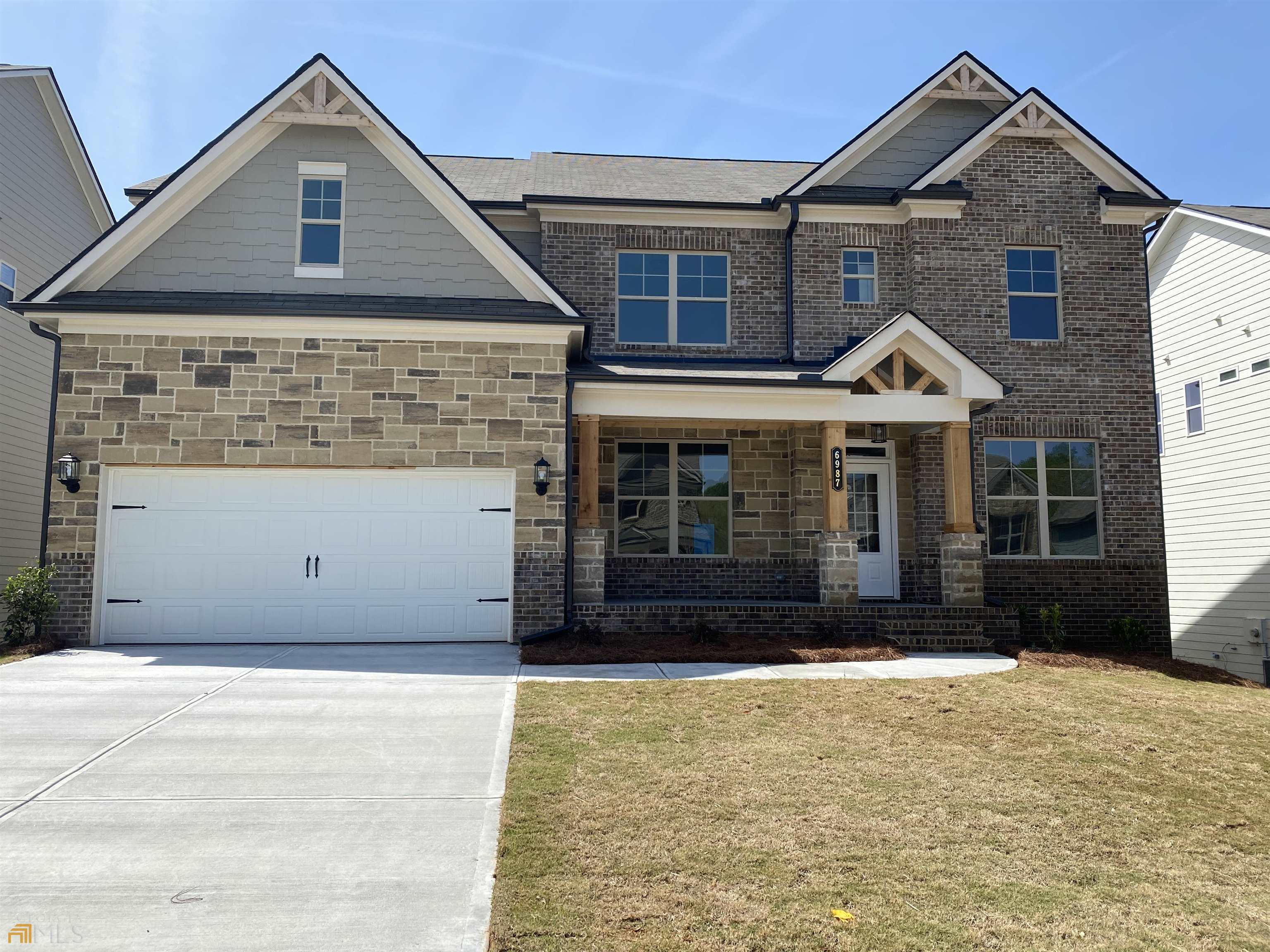6987 Lancaster Crossing, Unit 71A Flowery Branch, GA 30542 - Photo 1 of 1 a front view of a house with a yard and garage
