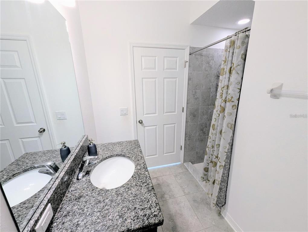 2944 Autumn Rock Drive Zephyrhills, FL 33540 - Photo 20 of 44 a bathroom with a granite countertop sink toilet and shower