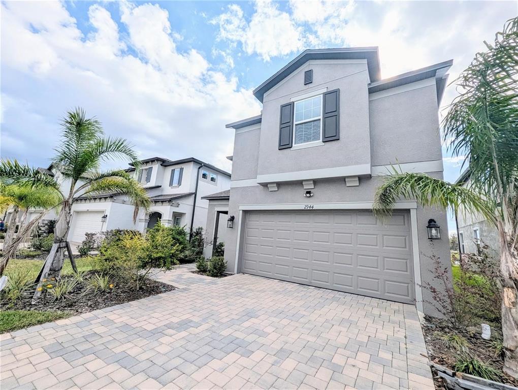 2944 Autumn Rock Drive Zephyrhills, FL 33540 - Photo 2 of 44 a front view of a house with a yard and garage