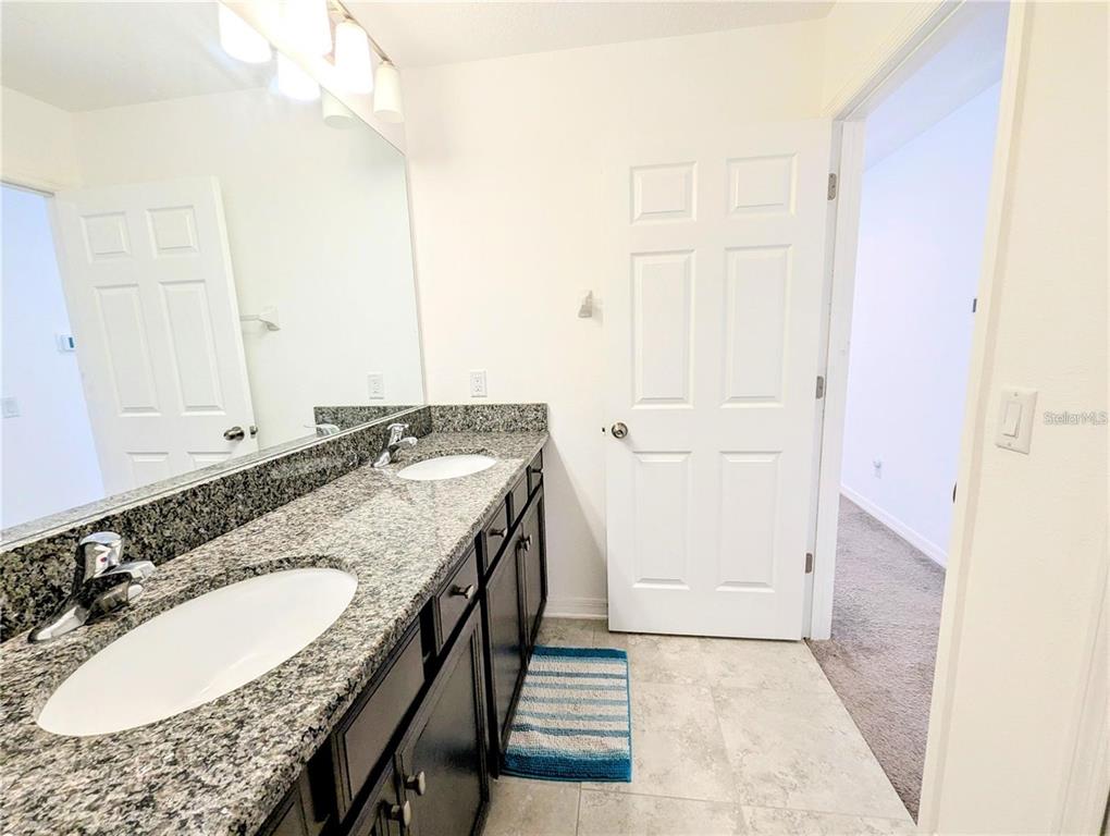 2944 Autumn Rock Drive Zephyrhills, FL 33540 - Photo 25 of 44 a bathroom with a granite countertop sink and a mirror