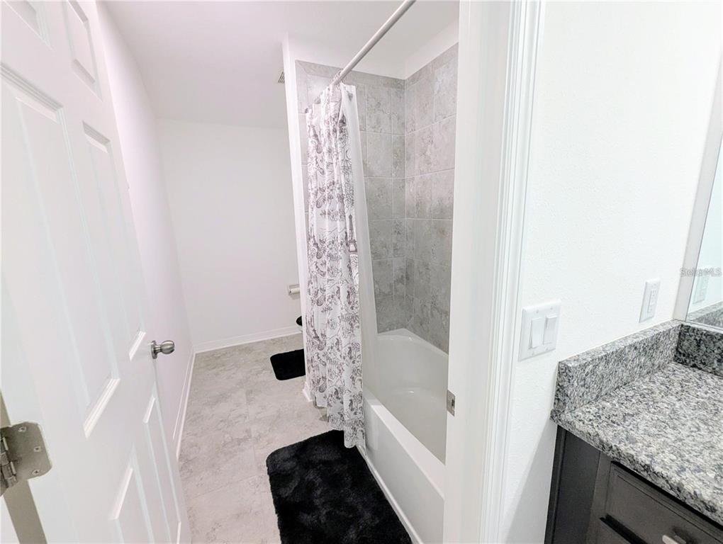 2944 Autumn Rock Drive Zephyrhills, FL 33540 - Photo 27 of 44 a bathroom with a granite countertop sink a toilet and shower