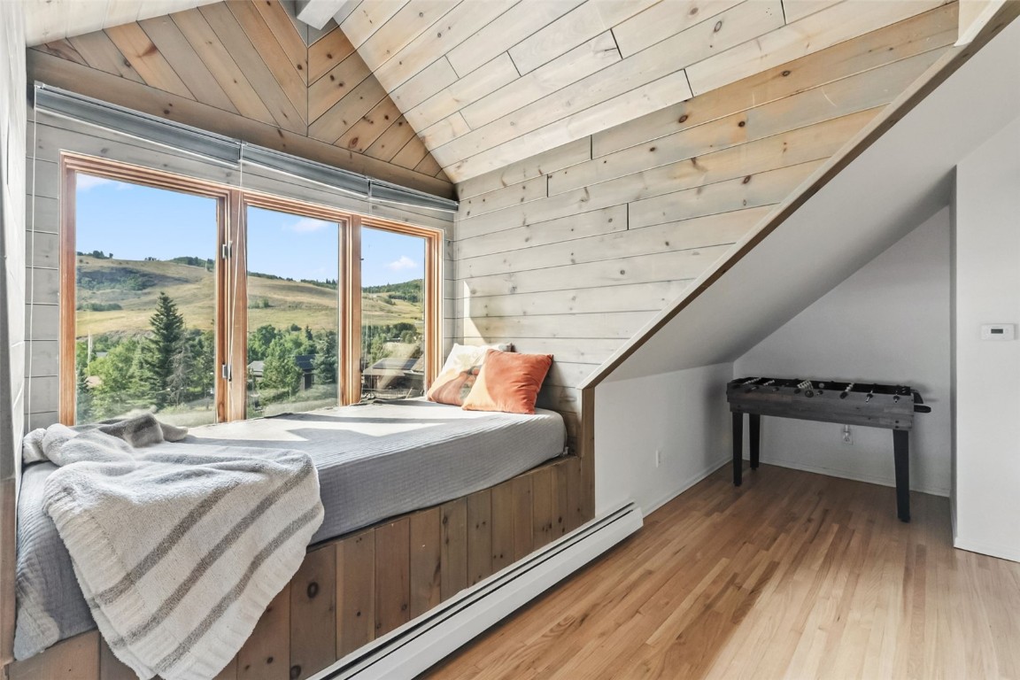 218 Deer Path Road Dillon, CO 80435 - Photo 26 of 49 a bedroom with a bed and a large window with wooden floor