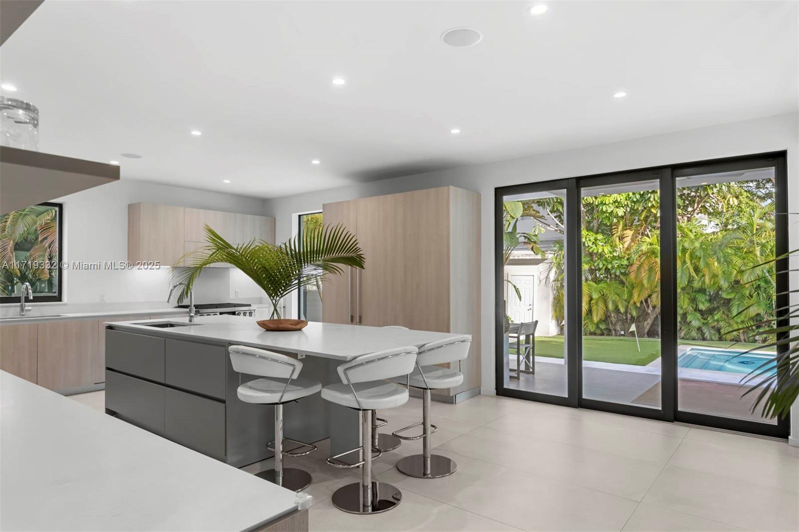 4301 Adams Avenue Miami Beach, FL 33140 - Photo 17 of 51 a kitchen with stainless steel appliances granite countertop a stove a refrigerator a kitchen island with white cabinets and wooden floor