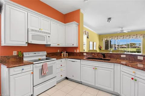 a kitchen with white cabinets sink and white appliances