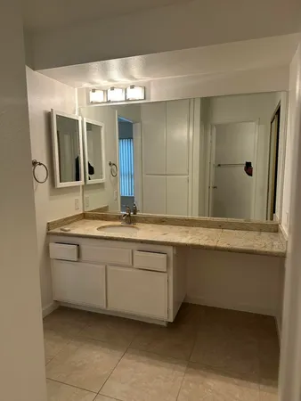 a bathroom with a granite countertop sink and a mirror