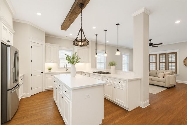 a kitchen with white cabinets and chandelier