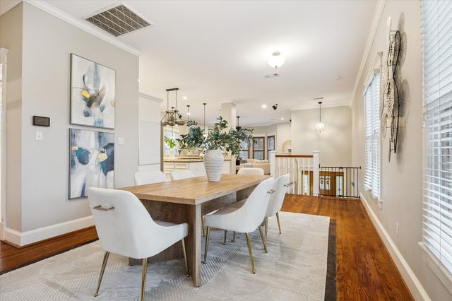 a dining room with furniture a chandelier and wooden floor
