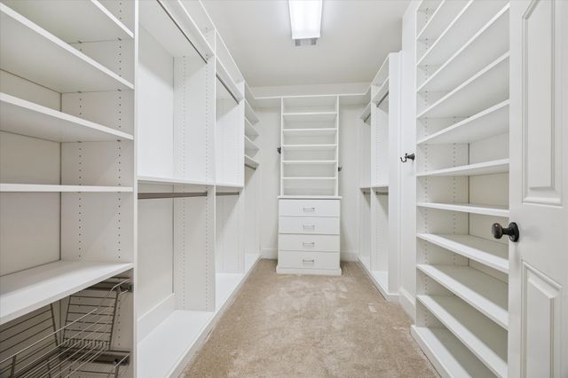 a spacious bedroom with a bed and large cabinets