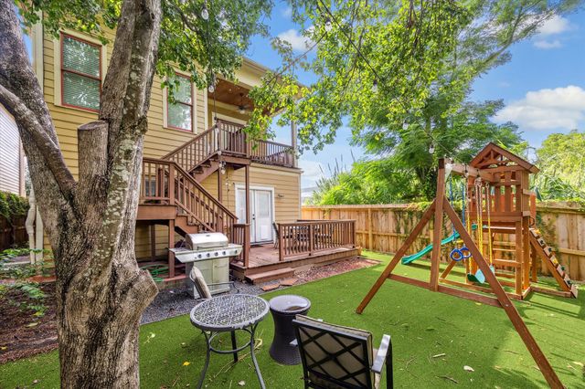 a view of a house with a backyard and a tree