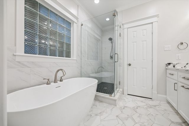 a bathroom with a tub shower and sink