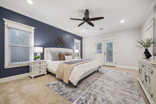 a bedroom with a large bed and a chandelier